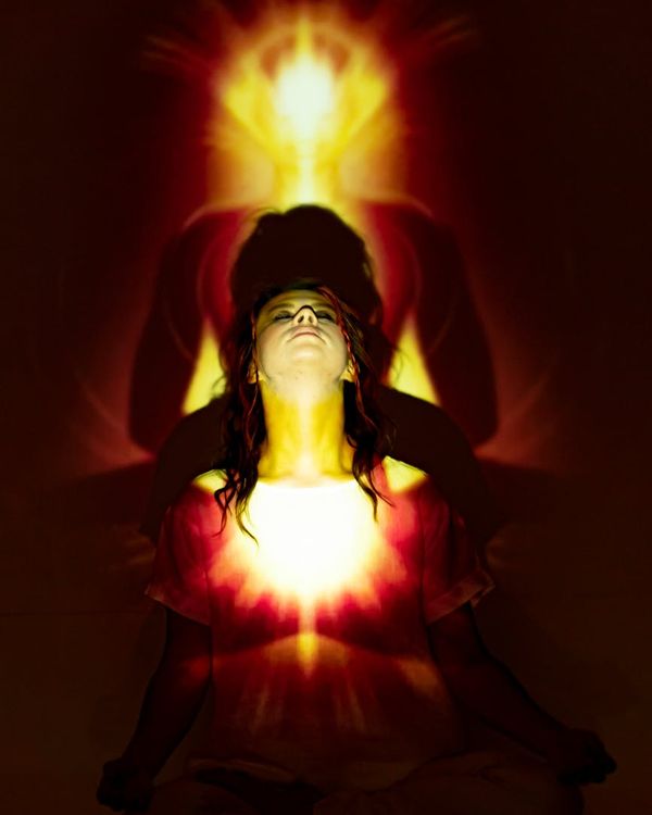 Woman in a flowing yoga pose with copper light accents.